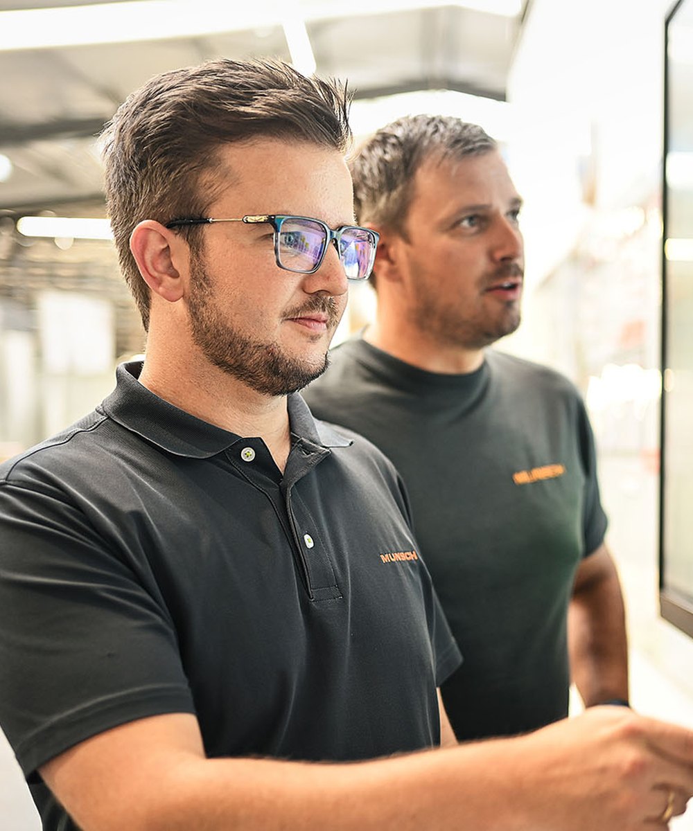 Zwei Mitarbeiter analysieren Produktionsdaten am Bildschirm