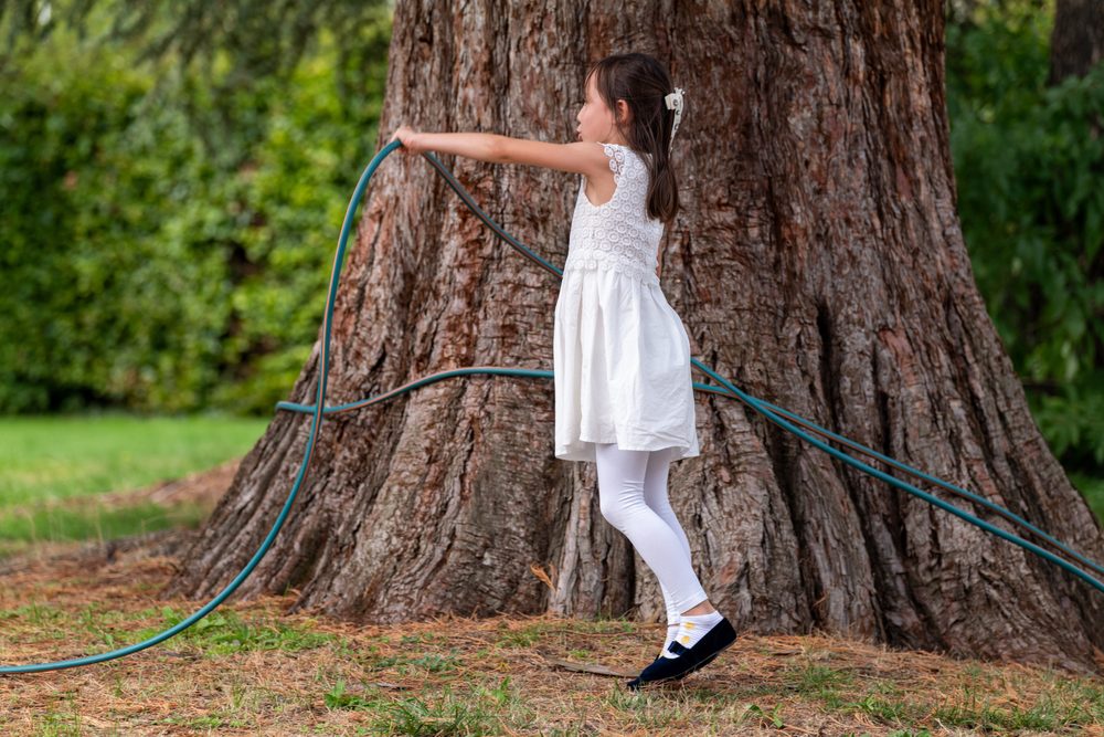 Mädchen umarmt einen Baum
